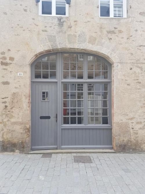 Porte d'entrée voûtée grise de l'appartement Ty Rose à La Conciergerie de Nathalie, Dinan, France