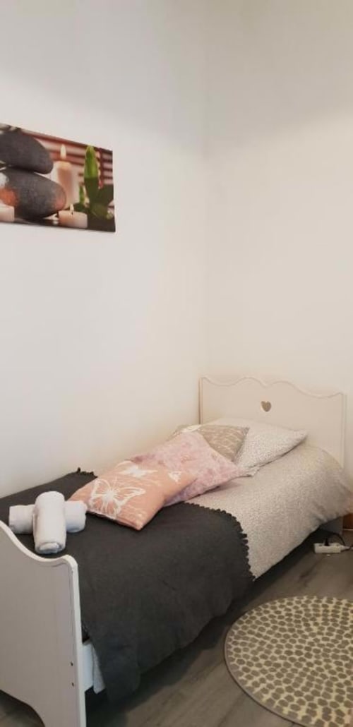 Chambre douillet à La Conciergerie de Nathalie, Dinan avec lit blanc, literie rose, bougies et œuvres murales