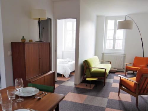 L'appartement Le Titouan à La Conciergerie de Nathalie à Dinan avec salle à manger, coin salon avec fauteuil jaune et boiseries