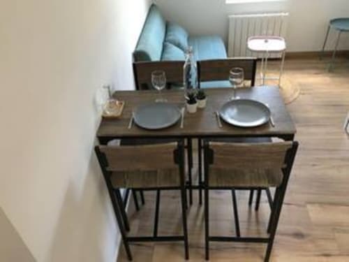 Coin repas de l'appartement Bohème à La Conciergerie de Nathalie, Dinan avec table dressée et coussins bleus