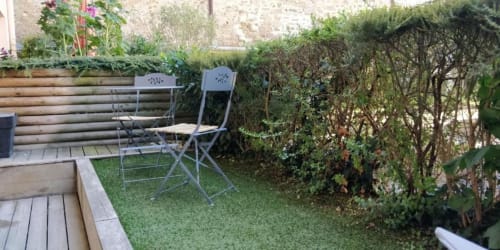Studio de jardin à La Conciergerie de Nathalie à Dinan avec salon de détente, chaises et jardinières en bois surélevées