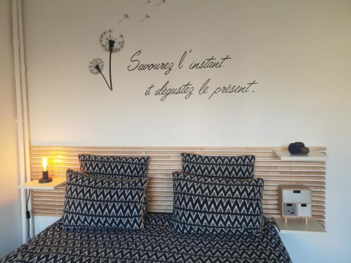 Chambre cosy à La Conciergerie de Nathalie à Dinan avec literie noire motifs et citation inspirante en français au mur