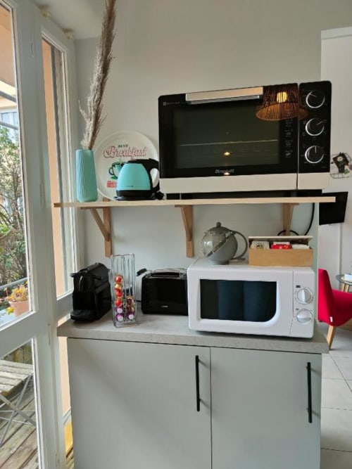 Cuisine moderne au Garden Studio de La Conciergerie de Nathalie à Dinan avec micro-ondes, four grille-pain et bouilloire turquoise