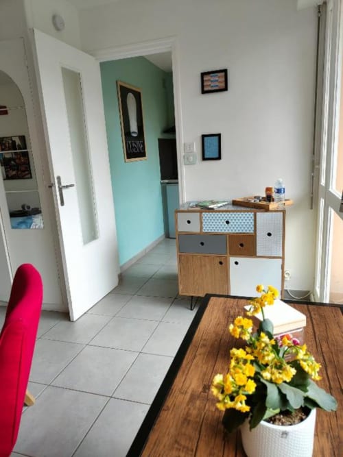 Studio lumineux à Dinan avec rangements modernes, fleurs jaunes et murs turquoise