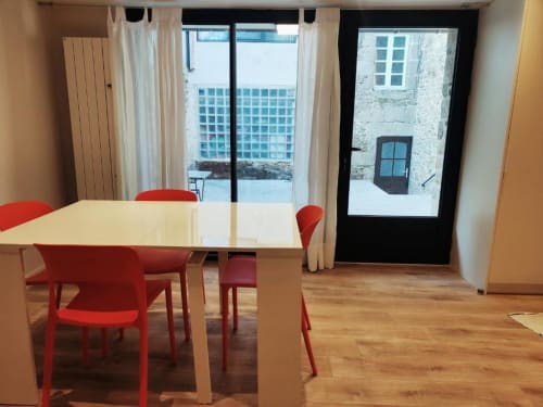Salle à manger contemporaine à la Villa Hortense, La Conciergerie de Nathalie, Dinan : chaises rouges, table blanche et vue sur la ville
