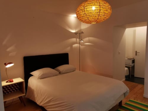 Chambre Anouk à La Conciergerie de Nathalie à Dinan avec lit, plafonnier en rotin et équipements modernes