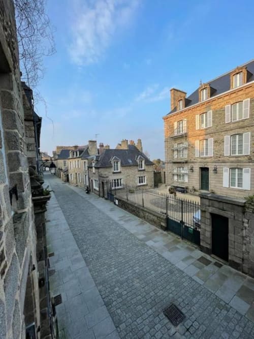 Charmante rue pavée à Dinan avec bâtiments historiques en pierre et vue dégagée sur le ciel