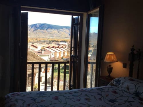Bedroom at Hotel Santorini Belgrade with balcony view of vineyards and mountains