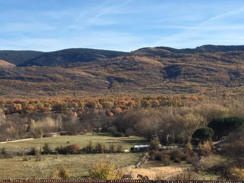 Paisaje de valle rural con árboles dorados de otoño, colinas ondulantes y casas de campo dispersas cerca de Belgrado