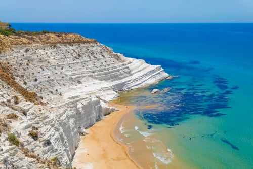 Scogliere di calcare bianco si affacciano su spiaggia di sabbia dorata e mare Mediterraneo turchese presso Stella Marina, Porto Empedocle