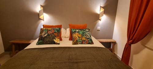 Chambre douillette du Relais des Îles : lit double, oreillers fleuris, appliques murales et vue sur mer à Saint-Marcouf