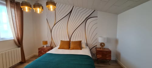 Modern bedroom at Relais des Iles cottage with teal bedding, gold accents, artistic headboard, pendant lights, and sea view
