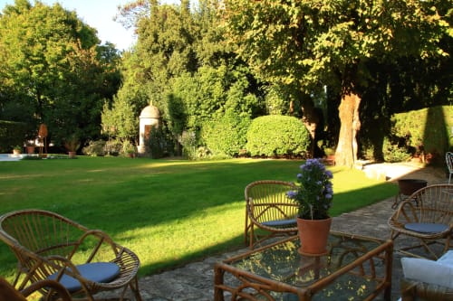Coin détente du jardin au Logis des Tourelles B&B à Cognac, avec fauteuils en osier et paysagisme luxuriant
