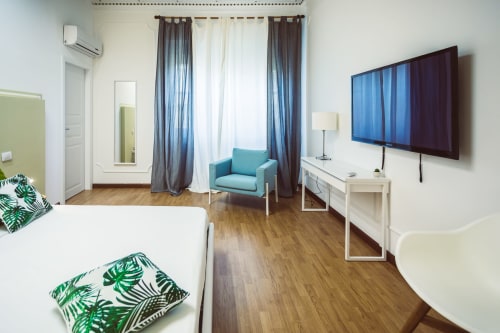 Bluemoon Sardinia Double King Room in Cagliari with city views, flat-screen TV, turquoise armchair, and modern amenities