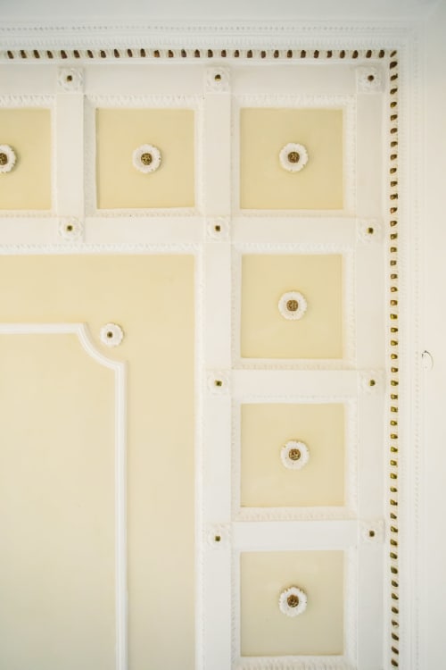Ceiling detail with white plasterwork, brass fixtures, and cream panels in Bluemoon Sardinia double king room, Cagliari