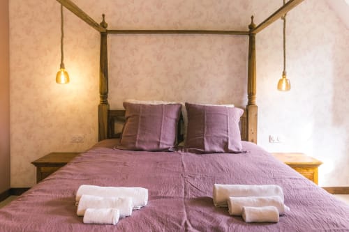 Élégant lit à baldaquin avec draps violets à Le Prieuré Du Preux B&B, chambre Les Clos avec vue sur le jardin