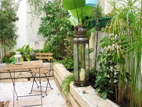 Lush rooftop garden at Apartments Uppe Villa, Lisboa, with seating area surrounded by climbing vines and potted plants