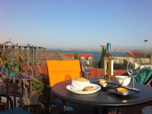 Rooftop dining at Uppe Villa Lisboa with wine, bread, and bay views
