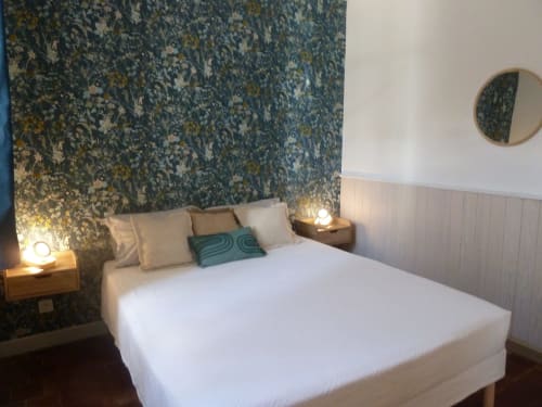 Modern bedroom at Château De Clusors B&B in St Menoux featuring floral wallpaper, white bedding, and warm lighting