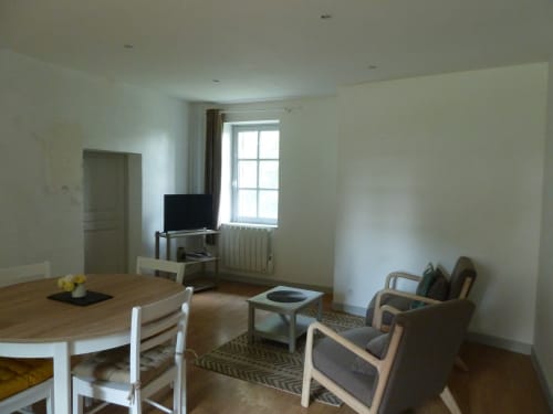 Luminosa habitación de huéspedes en Château De Clusors con mesa de comedor, TV, cómoda zona de estar y luz natural de gran ventanal
