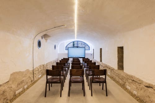 Salle de cinéma souterraine avec chaises en bois à l'Hôtel La Prison de Béziers, France
