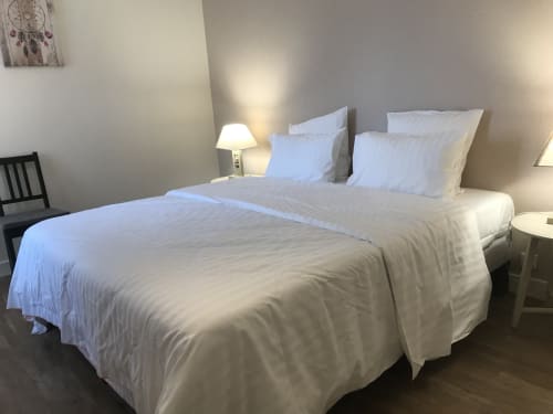 Deux lits simples aux draps blancs dans une chambre moderne et lumineuse au Chablis Appart, chambre d'hôtes à Chablis, France