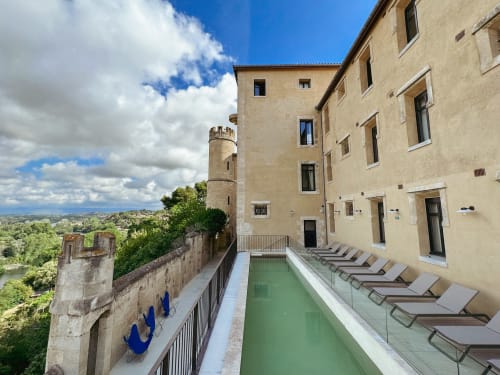 Terraza con piscina del Hotel La Prison Béziers con vistas a la torre del castillo y el valle