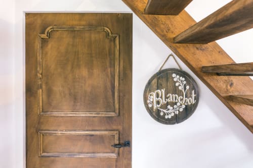 Porte en bois avec enseigne Blanchot circulaire et poutres apparentes à Le Prieuré Du Preux, boutique-hôtel en France