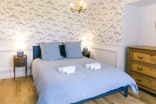 Chambre Blanchot au Prieuré du Preux avec lit bleu, papier peint classique, vue sur le jardin et mobilier en bois