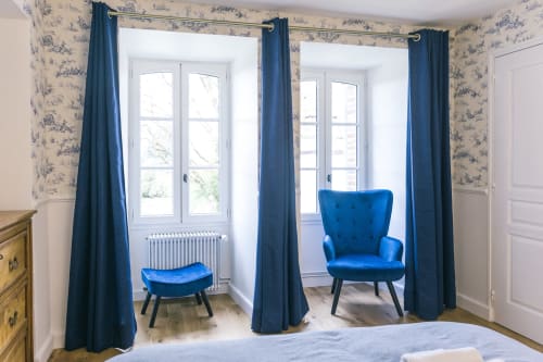 Chambre Blanchot au Prieuré du Preux avec fauteuil en velours bleu, repose-pieds, portes donnant sur le jardin et papier peint toile à Sépeaux Saint