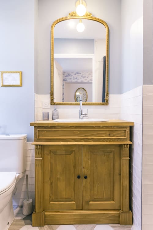 Élégante vanité de salle de bain avec meuble en bois et miroir doré au Prieuré Du Preux, boutique B&B à Sépeaux Saint Romain