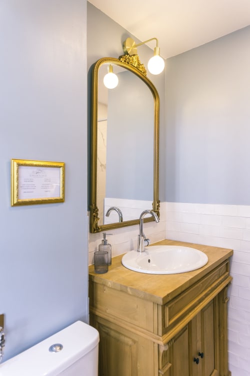 Élégant lavabo de salle de bains avec miroir doré orné et appliques au Prieuré Du Preux, Sépeaux Saint Romain
