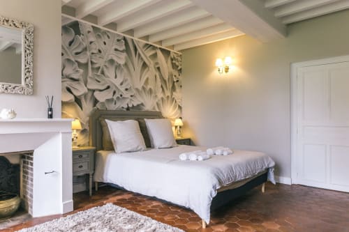 Valmur room at Le Prieuré Du Preux with garden view, elegant bed, fireplace, and decorative leaf artwork
