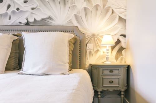 Elegant Valmur bedroom at Le Prieuré Du Preux with upholstered headboard, white pillows, and ornate ceiling details