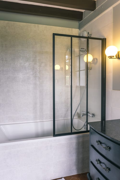 Modern bathroom with black-framed glass shower enclosure at Le Prieuré Du Preux, Valmur room