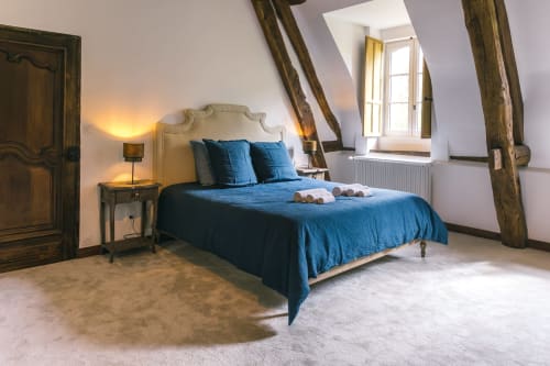 Chambre mansardée cosy avec literie bleue et poutres apparentes au Prieuré Du Preux, Sépeaux Saint Romain