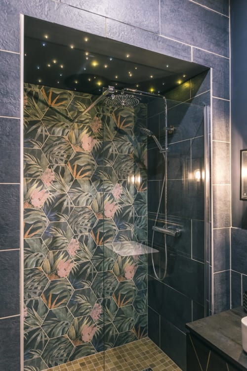 Douche moderne au Le Prieuré Du Preux avec carrelage à motifs botaniques, pommeau de douche pluie et éclairage d'ambiance