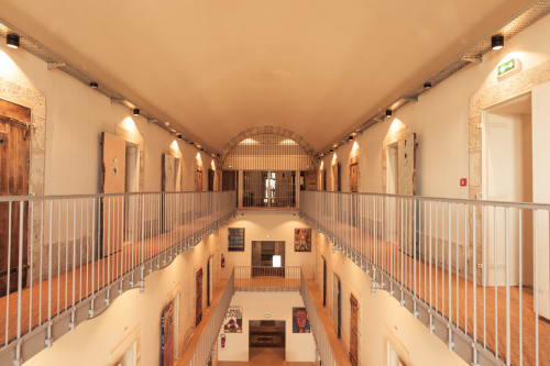 Pasillo multinivel con techo abovedado y barandillas metálicas en el Hotel La Prison de Béziers, Francia
