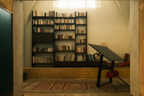 Estantería negra con escritorio en la sala de biblioteca del Hotel La Prison, Béziers