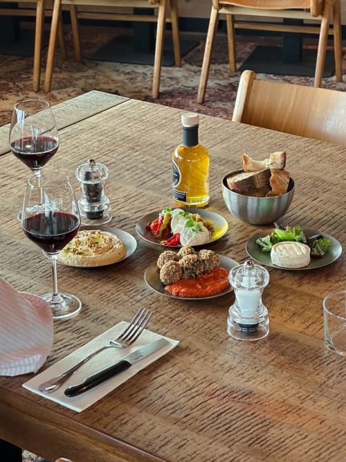 Tabla de vino y charcutería en el Hotel La Prison de Béziers, con vino tinto, queso, embutidos y verduras frescas