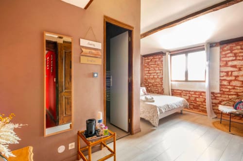 Bohème-Zimmer im La Maison de la Colline in Vers, Frankreich mit Terrakottawänden, sichtbarem Mauerwerk, Holzbalken und Garten