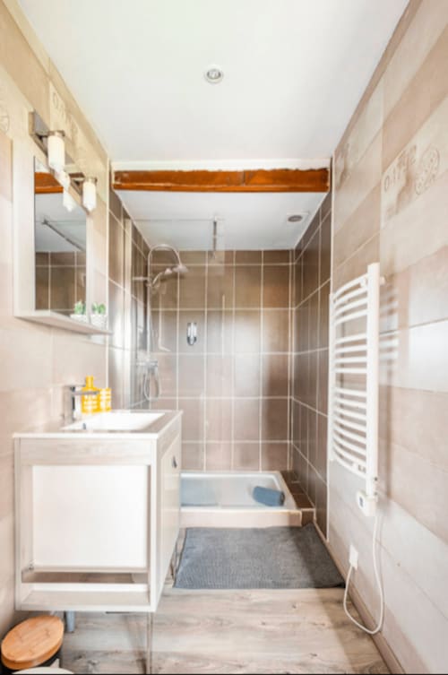 Modernes Badezimmer in La Maison de la Colline mit begehbarer Dusche, weißem Waschtisch, beheiztem Handtuchhalter und Holzakzenten