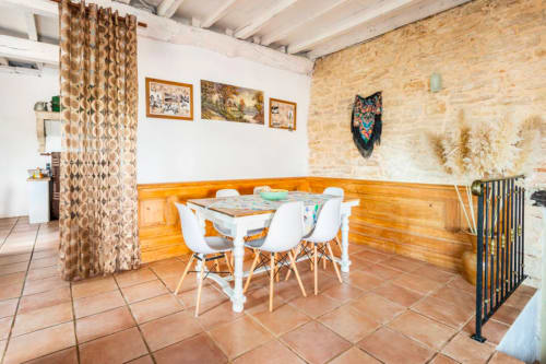 Empfangshalle in La Maison de la Colline in Vers, Frankreich, mit Speisebereich, weißem Tisch und Stühlen, Steinwänden