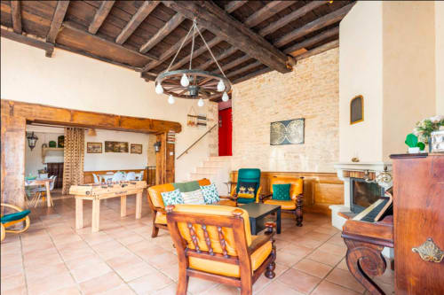 Empfangsraum La Maison de la Colline in Vers, Frankreich mit rustikalen Holzbalken, Kamin und gemütlichem Sitzbereich