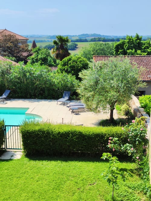 Espace piscine Le Rêve d'Alice aux eaux turquoise, transats, jardins luxuriants et vue sur la campagne toscane à Saint-Puy
