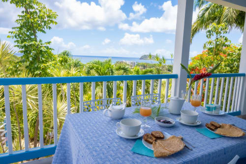 Petit déjeuner paradisiaque de la "Résidence Vue Mer" en Guadeloupe avec une vue à couper le souffle sur les Caraïbes.