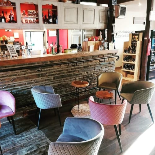 Chaises matelassées colorées autour de tables en bois au salon de l'Hôtel Le 24 à Spa, Belgique