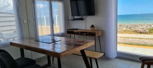 Modern cottage living room with sea view, flat-screen TV, dining table, and beach terrace access at Relais des Iles,