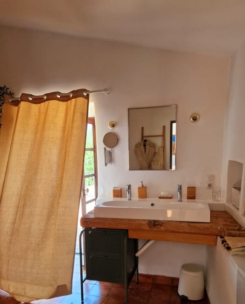 Élégante salle de bain avec meuble-lavabo en bois, vasque blanche et miroir doré à Las Fincas De Annie