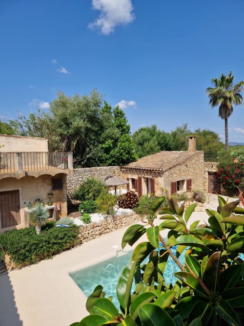 Villa Las Fincas De Annie à Felanitx avec piscine, architecture en pierre, palmiers et vue sur les montagnes